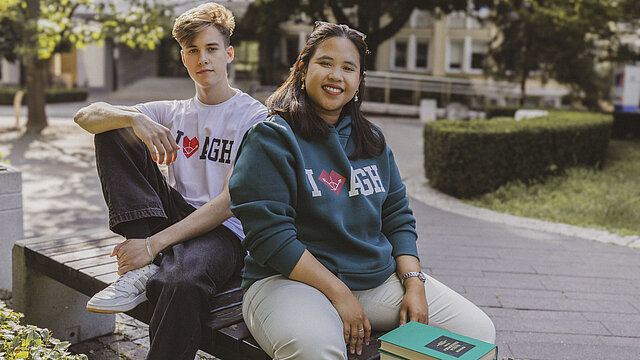 Dwie młode osoby w bluzach sygnowanych logo AGH